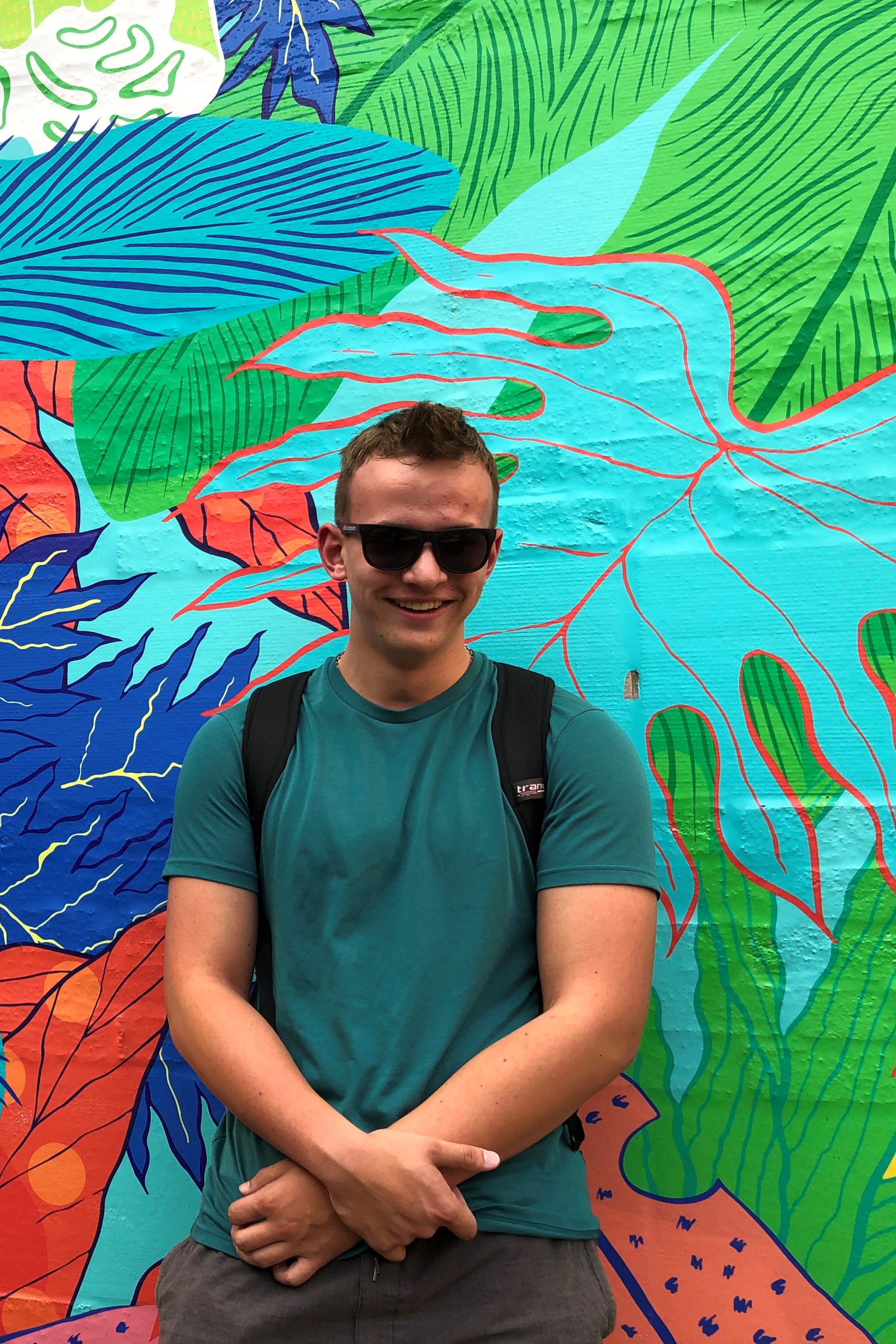 Image of Jakub Krasewicz wearing sunglasses standing in front of a colorful wall